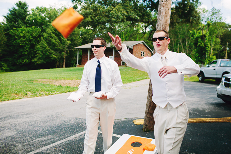 groom playing cornhole